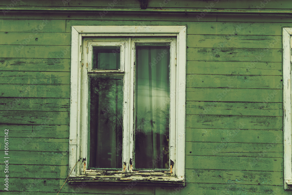 The old dilapidated window frame house green