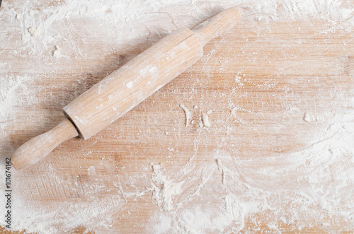 Rolling pin on a wooden tray covered with flour