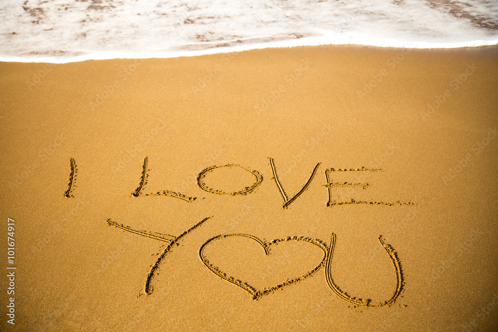 I Love You message written in sand; summer background, sea and sand background