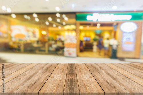 Wooden board empty table in front of blurred background. Perspective brown wood over blur in restaurant - can be used for display or montage your products.Mock up for display of product. © tirachard