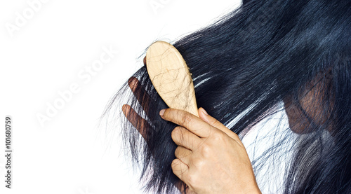 woman losing hair as she brush on hairbrush photo