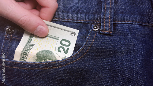 Hand pulls money out of pocket jeans
