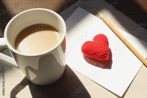 Red love hearts on brown paper note with a cup of coffee, light soft tone, valentines day card concept.