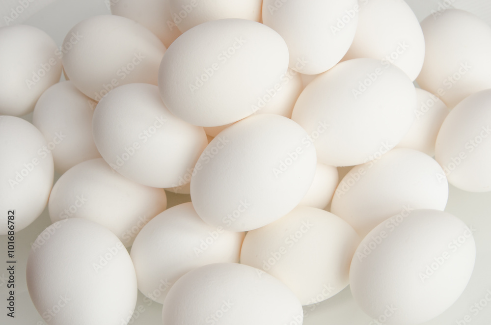 A close up of a pile of white farm eggs