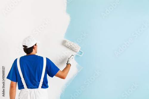 painter painting a wall with paint roller photo