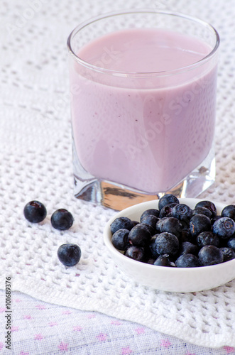 Blueberry yogurt in a glass with a spoon and blueberries