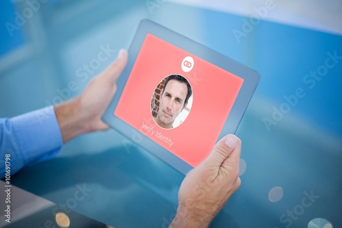 Composite image of businessman using his tablet 