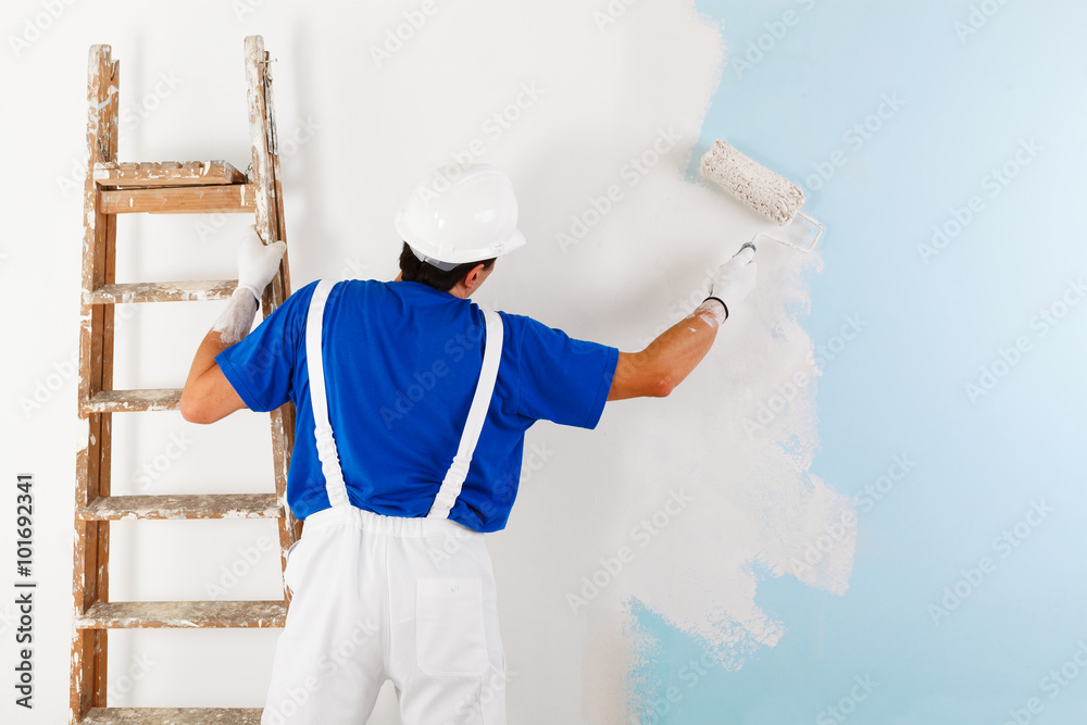 painter painting a wall with paint roller Photos | Adobe Stock