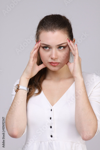 Beautiful young woman with headache touching her temples