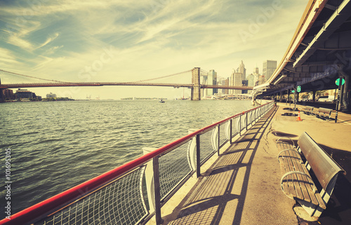 Retro stylized picture of East River with Brooklyn Bridge in distance, New York city, USA.
