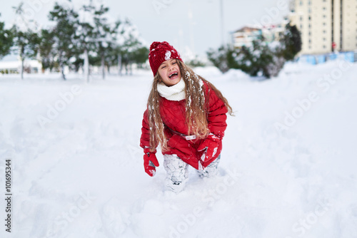 laughing girl running in snow-covered park