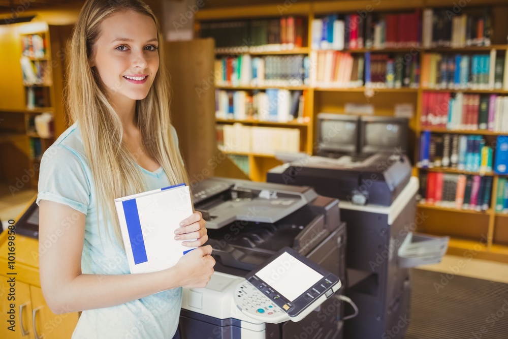 Smiling blonde student making a copy Smiling blonde student making a copy