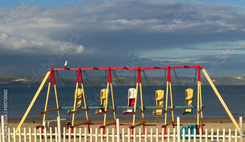 Принти на полотні Beach swings stand idle in the evening sun on a deserted British beach