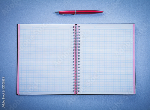 Assortment of red ball-point pen open copybook office concept