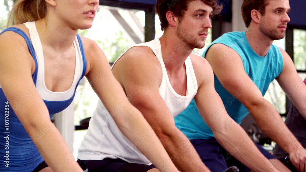 Fit group of people using exercise bike together Fit group of people using exercise bike together