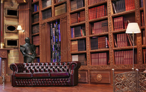 Classical library room with leather armchair, wooden table and bookcase photo