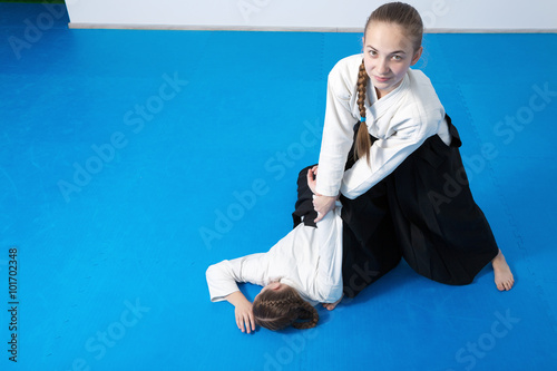 Two girls in black hakama practice Aikido