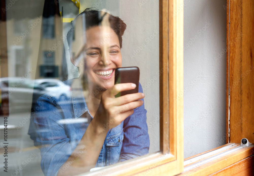 Attractive young woman smiling and using mobile phone Attractive young woman smiling and using mobile phone