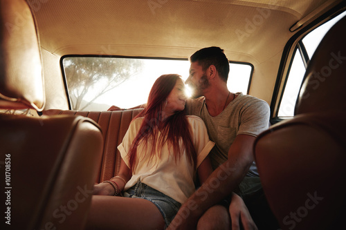 Affectionate young couple in rear seat of a car © Jacob Lund