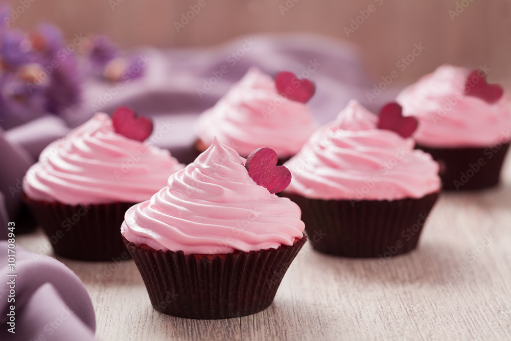 Cupcakes traditional celebration sweet dessert with pink cream and red hearts in row on vintage background