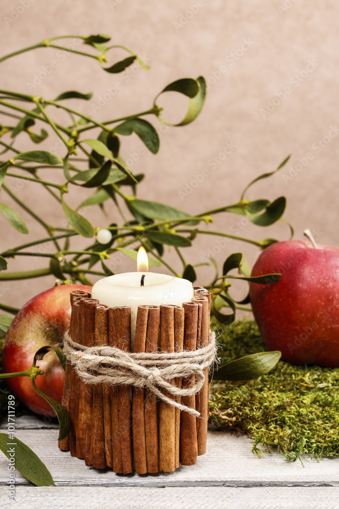 Candle decorated with cinnamon sticks