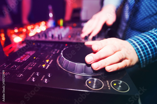 Club DJ playing mixing music on vinyl turntable