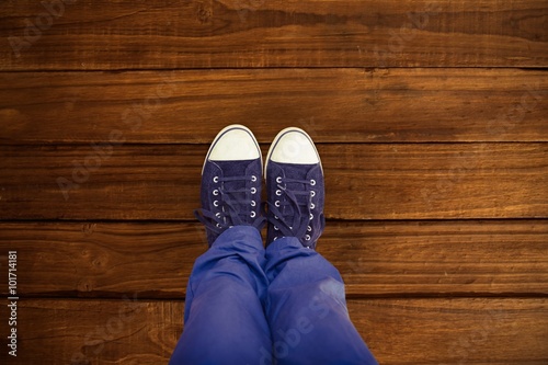 Composite image of low section of man standing on hardwood floor