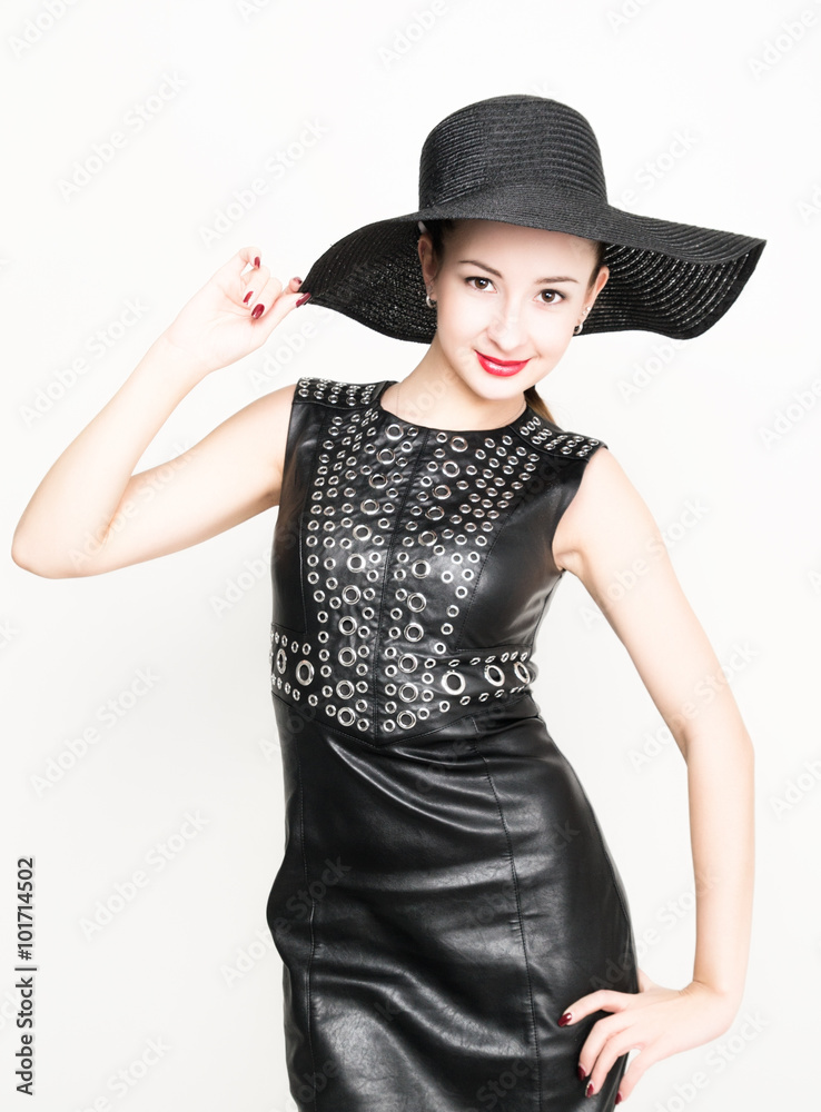 sexy young woman in black leather dress with braided hair. a big black hat on his head sexy young woman in black leather dress with braided hair. a big black hat on his head