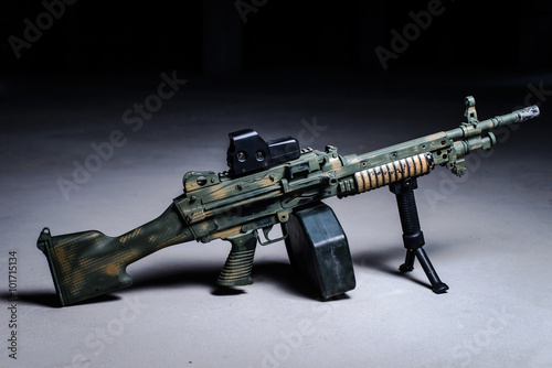 Machine gun on the ground/Machine gun with camouflage pattern on the ground on dark background