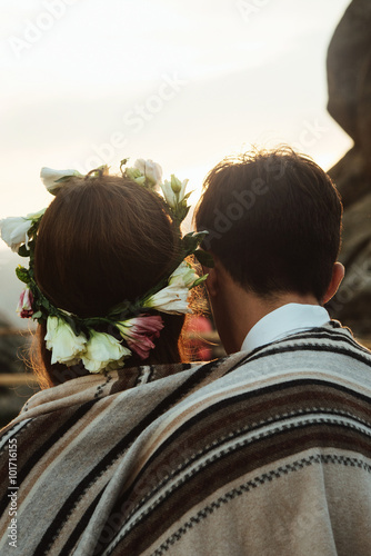 happy luxury couple newlyweds looking at sunset hugging under ru