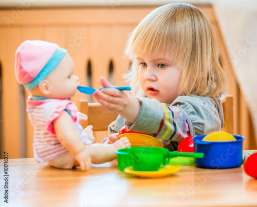 girl feeding a doll 