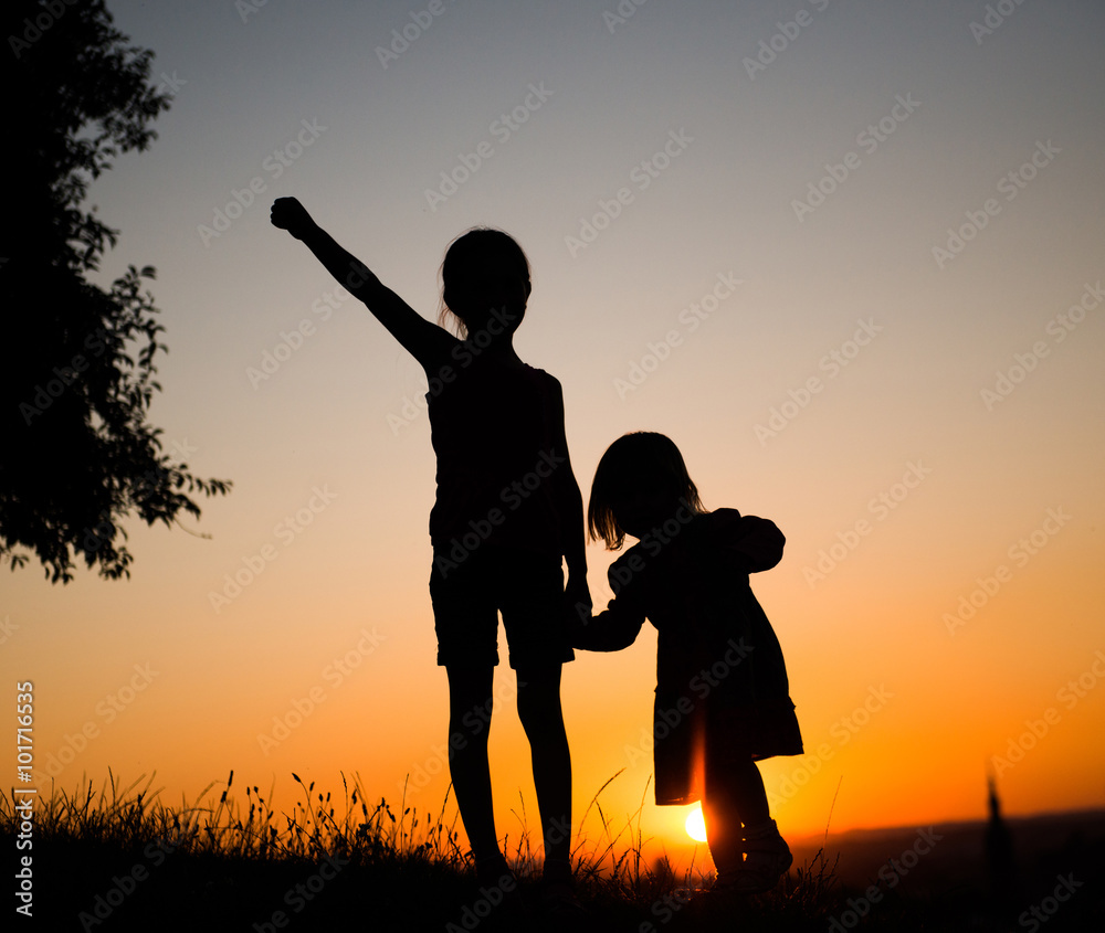Silhouette of two young sisters 