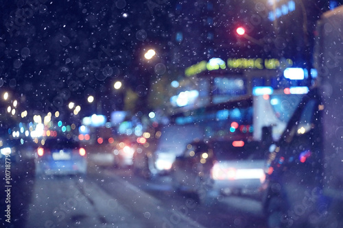 city lights on winter road, blurred background snowfall