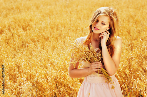Молодая красивая девушка в пшеничном поле с рыжими волосами