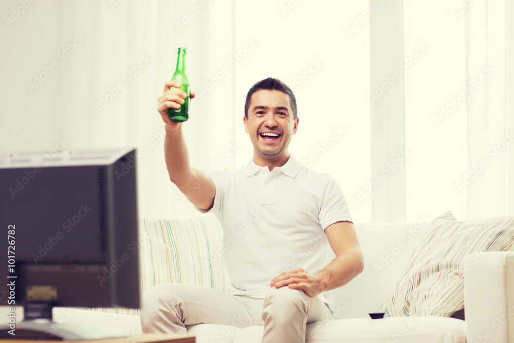 smiling man watching tv and drinking beer at home smiling man watching tv and drinking beer at home