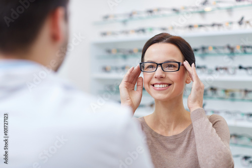 woman showing glasses to optician at optics store photo