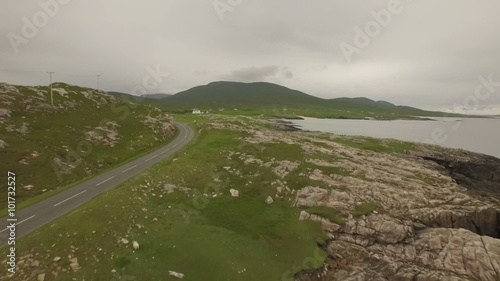 Stunning aerial shot on the Isle of Harris, Scotland near the coast flying over a small fishing boat
 photo