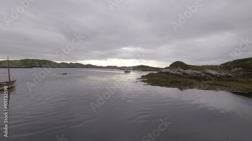Stunning aerial shot on the Isle of Harris, Scotland near the coast flying over a small fishing boat
 photo