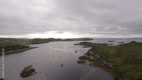 Stunning aerial shot on the Isle of Harris, Scotland near the coast flying over a small fishing boat
 photo