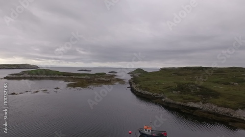 Stunning aerial shot on the Isle of Harris, Scotland near the coast flying over a small fishing boat
 photo