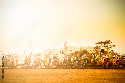 Old motorbike on a mountain in sunrise with mist. photo