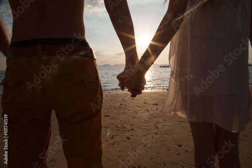 Couple holding hands, coastline.