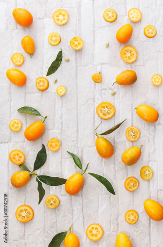 Fresh organic kumquats. Kumquats whole and sliced  still life pattern background  overhead view