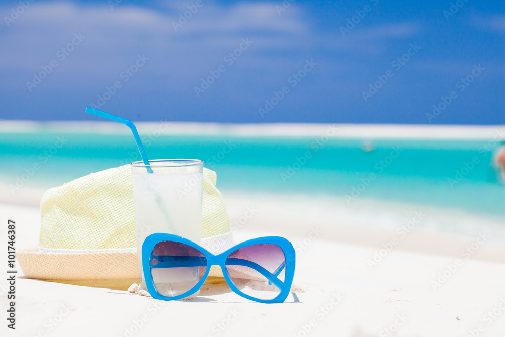 sunglasses and straw hat on tropical beach