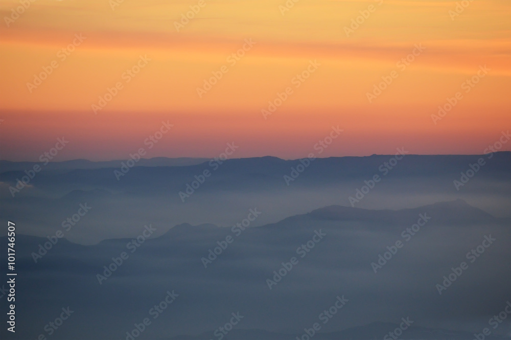 coucher de soleil en montagne dans la brume