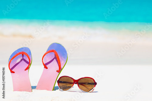 bright flip flops and sunglasses on a tropical sea resort background
