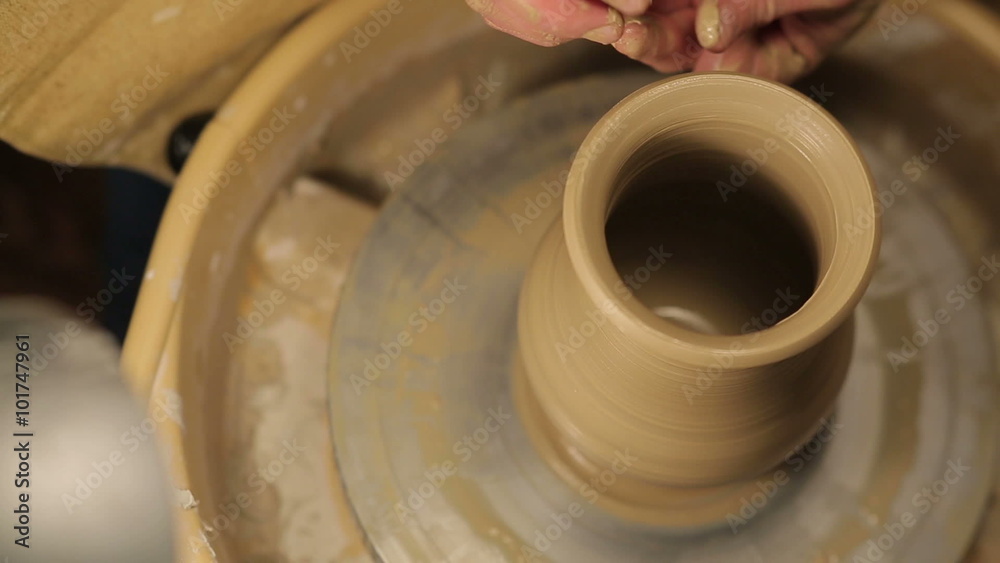 hands of a potter, creating an earthen jar on the circle