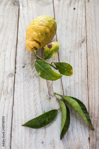 limone biologico con foglie su asse di legno