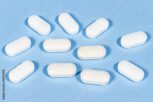 Generic tablets of clavulanic acid on blue floor. Antibiotic drugs