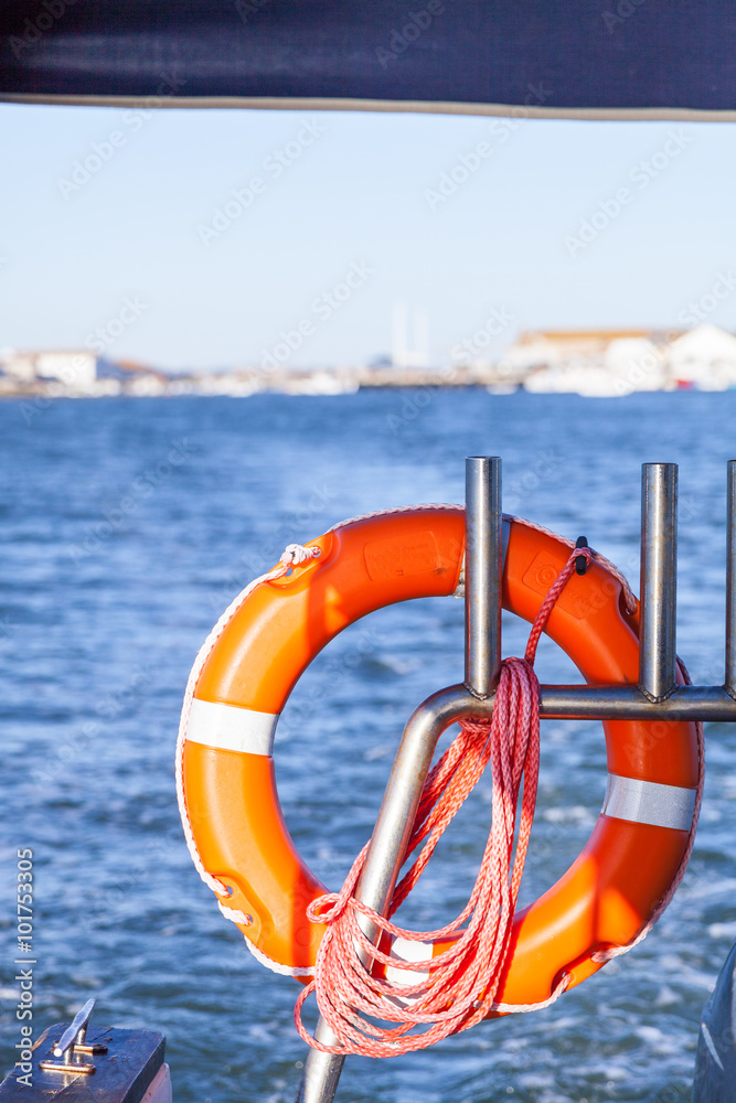 Lifebuoy and rope hanging on metal railing